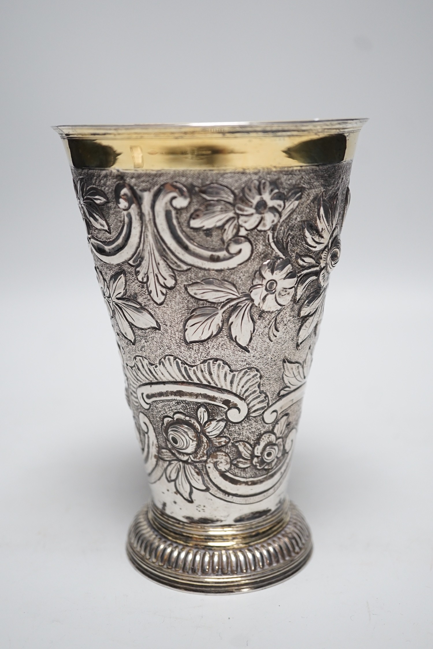 A 19th century Swiss? embossed parcel gilt white metal flared vase, maker's mark AWM, engraved with two armorials, height 17cm, 10.8oz.